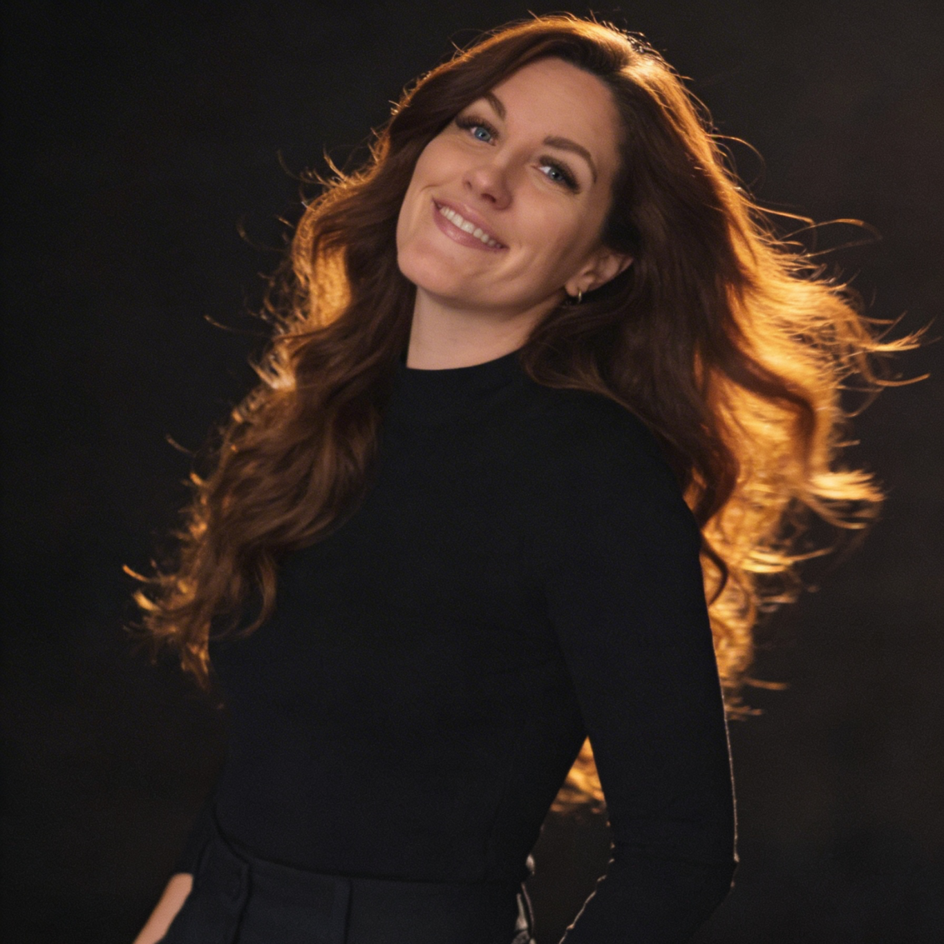 Vorher-Nachher Website – Überarbeitung einer Wix Website Eine Frau mit langen, lockigen Haaren arbeitet an einem Laptop in einem gemütlichen Raum.